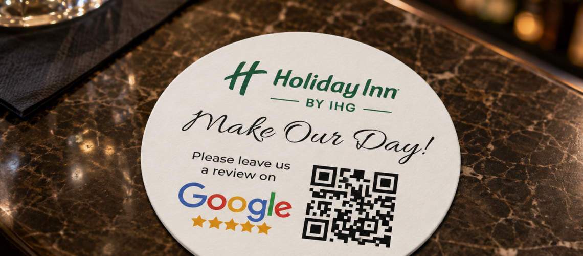 Round personalised Holiday Inn coaster displayed on a hotel bar table, featuring branding, a Google review request and a QR code.